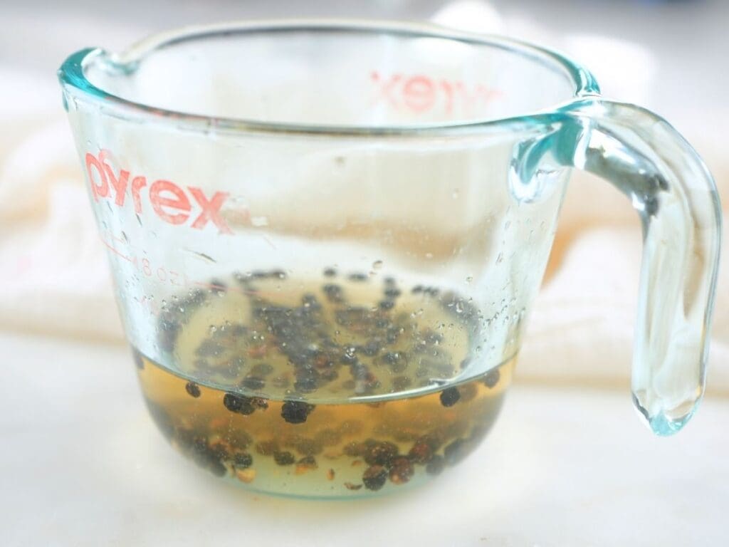 A glass measuring cup filled with brine.