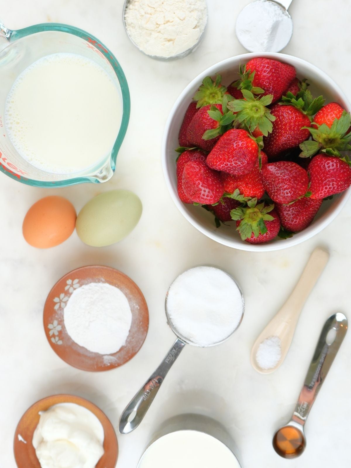 Sourdough strawberry shortcake ingredients scattered on a counter.