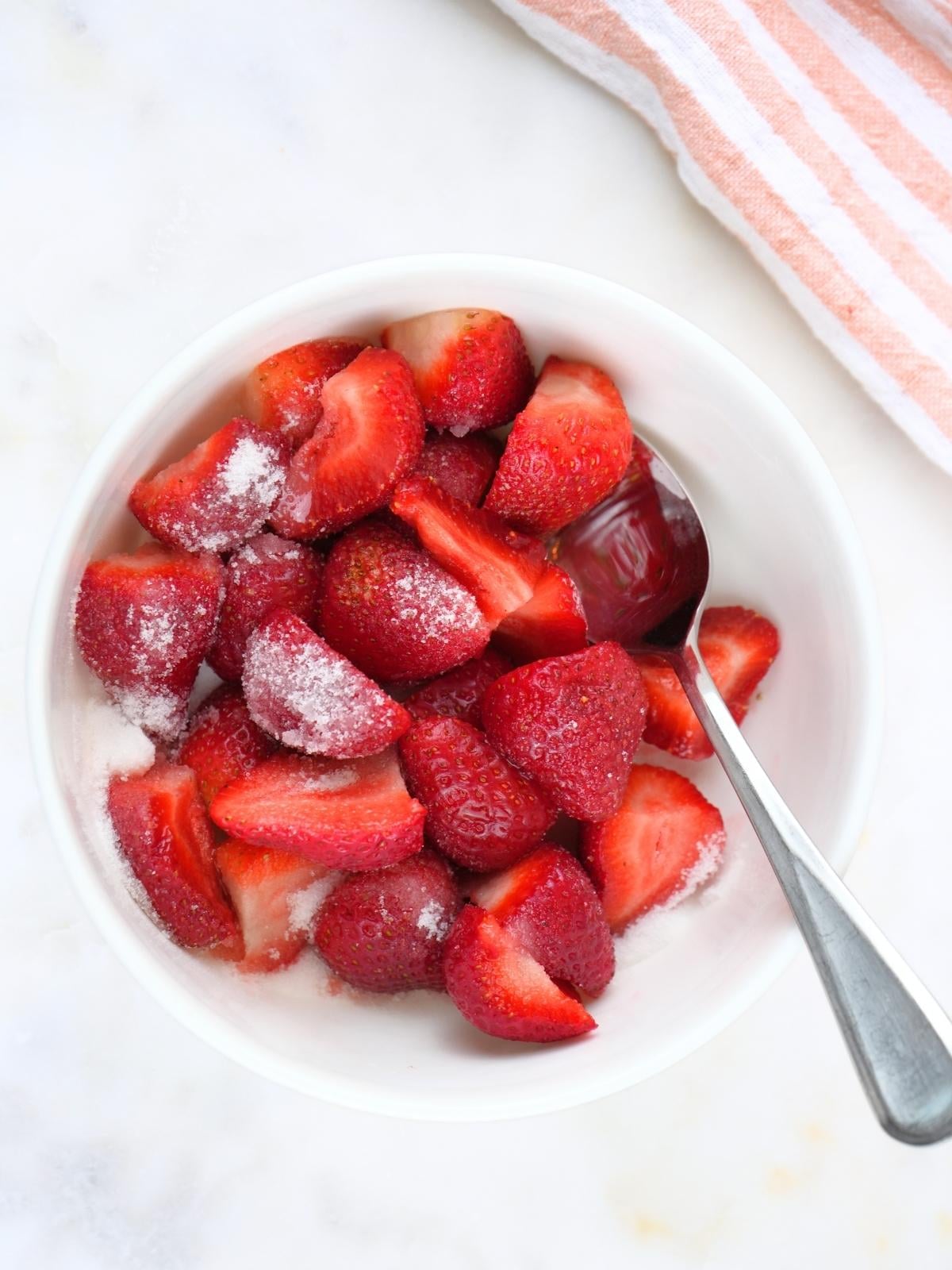 Strawberries in a bowl, sprinkled with sugar.