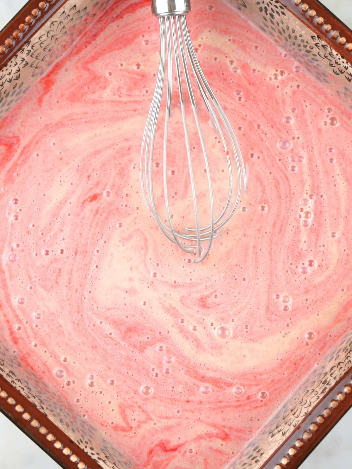 Strawberry ice cream mixture in a baking dish before churning.