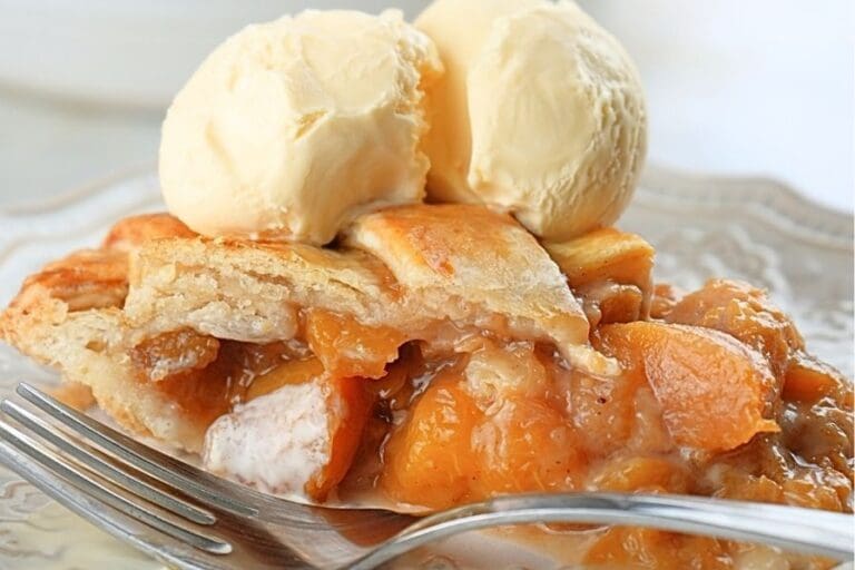A slice of sourdough peach pie topped with two scoops of vanilla ice cream