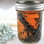 A jar of homemade vanilla extract sitting on the counter