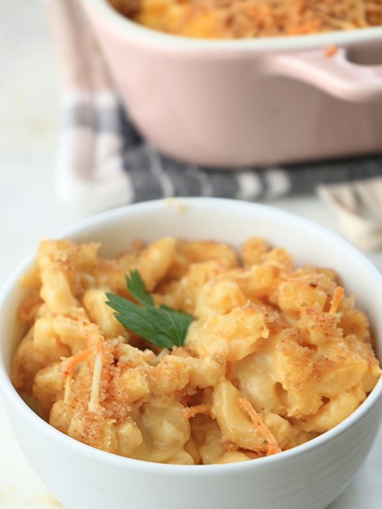 A small bowl of sourdough mac and cheese with fresh herbs on top