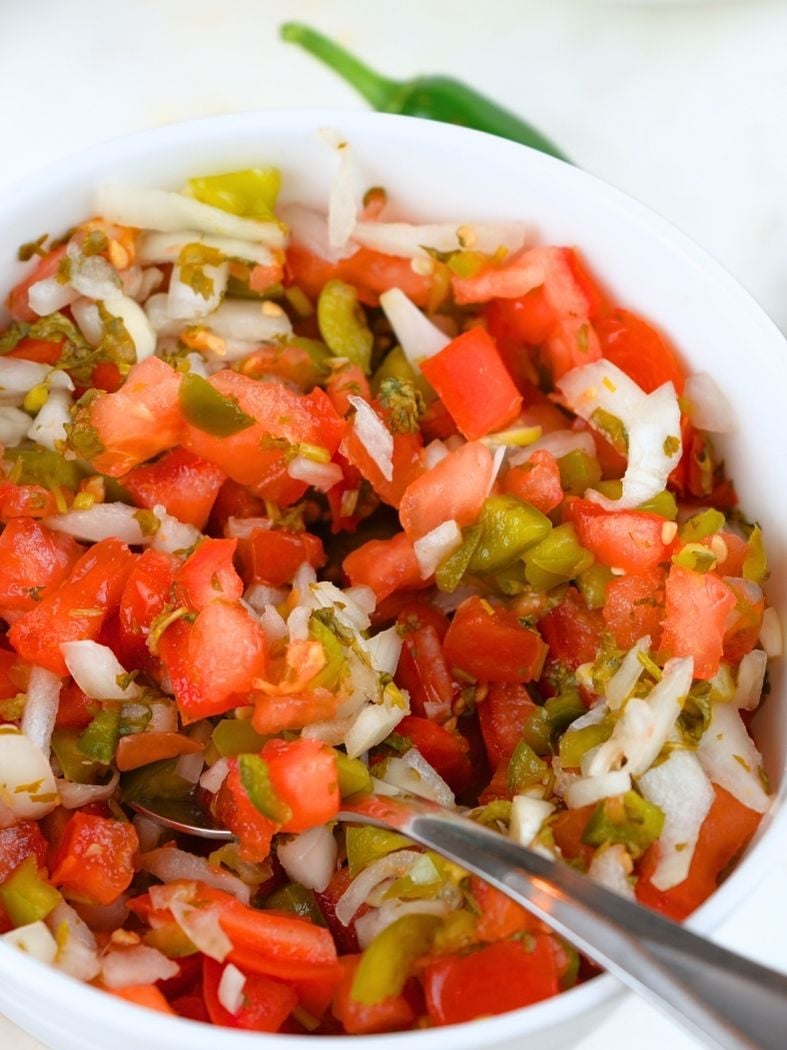 A bowl of fermented salsa with a spoon in it