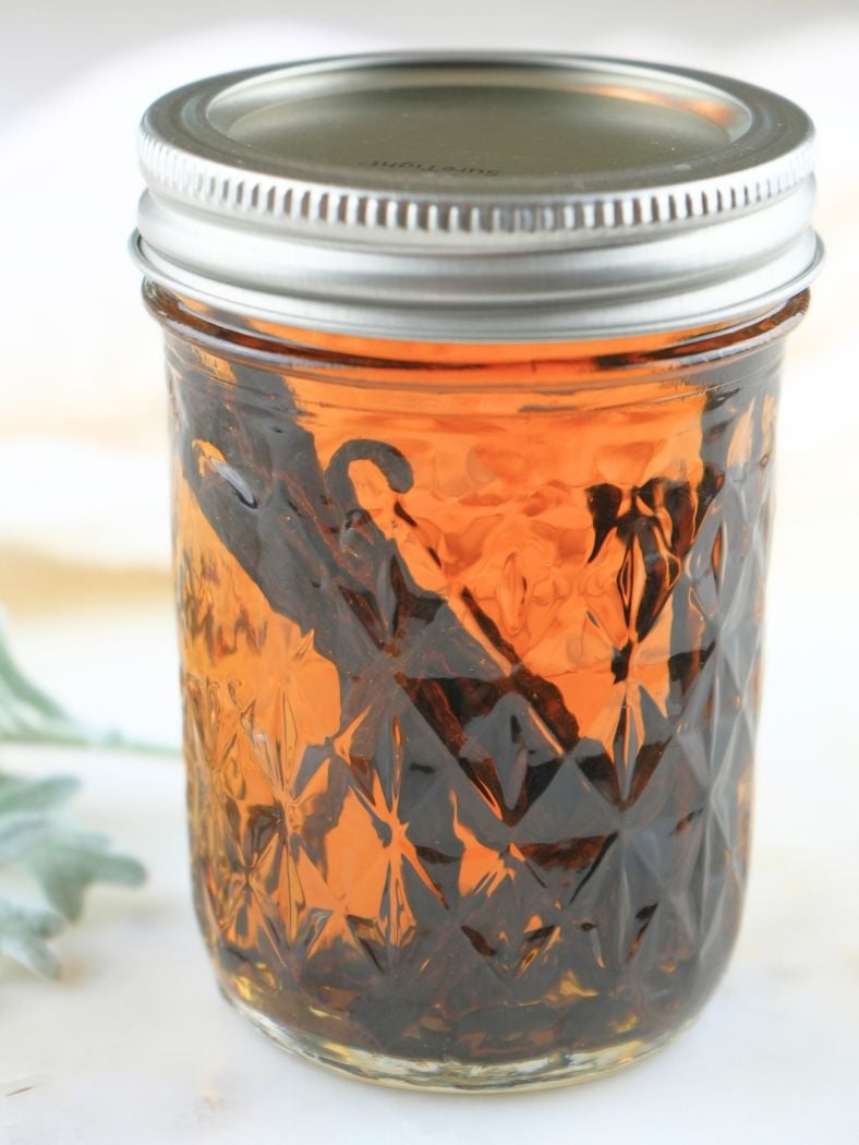 Homemade vanilla extract in a mason jar sealed with a metal lid and ring