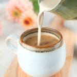 Homemade brown sugar coffee cream being poured into a coffee mug.