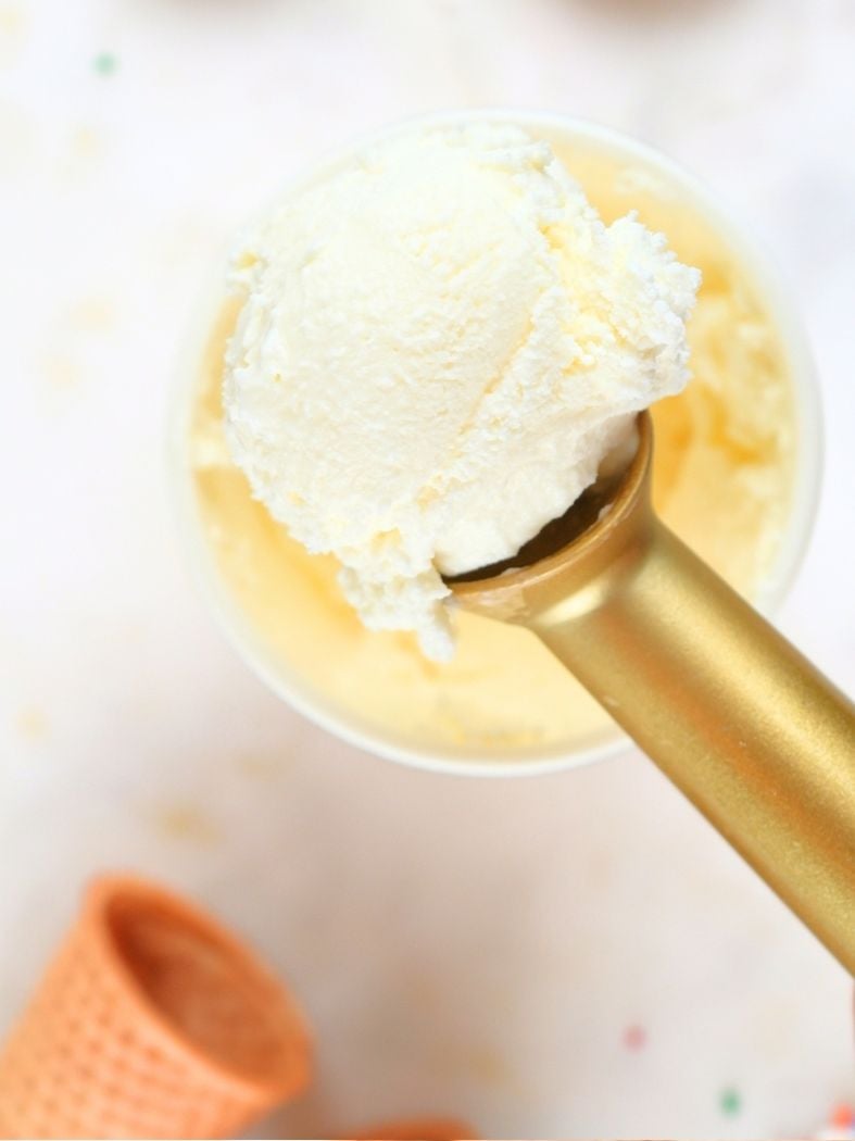 A close up of homemade vanilla ice cream (no egg) in a gold scoop