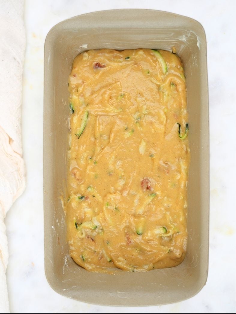 A stone loaf pan filled with sourdough discard zucchini bread batter
