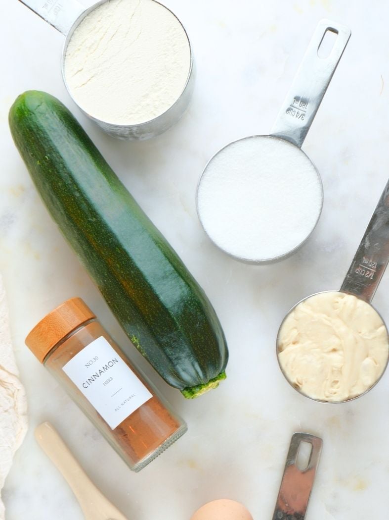 A close up of a zucchini and baking ingredients