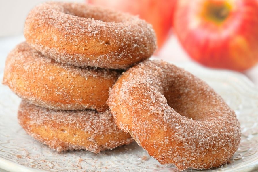 Close up of sourdough apple cider donuts stacked on a plate