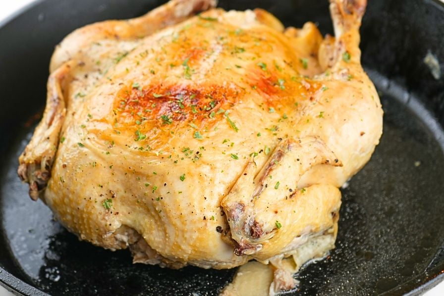 A whole chicken resting on a skillet that was cooked from frozen in an Instant Pot