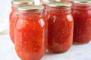 Jars of crushed tomatoes lined up on a counter