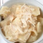 A small bowl of chicken and pastry with a fork next to It