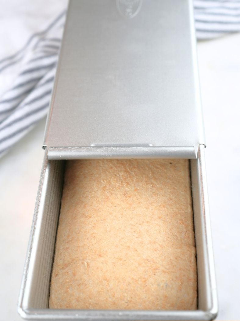 Proof dough in a Pullman pan with the lid halfway on