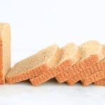 A fresh-milled sourdough pullman loaf with sliced fanned in front of it