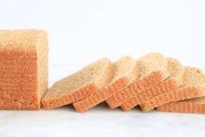 A fresh-milled sourdough pullman loaf with sliced fanned in front of it
