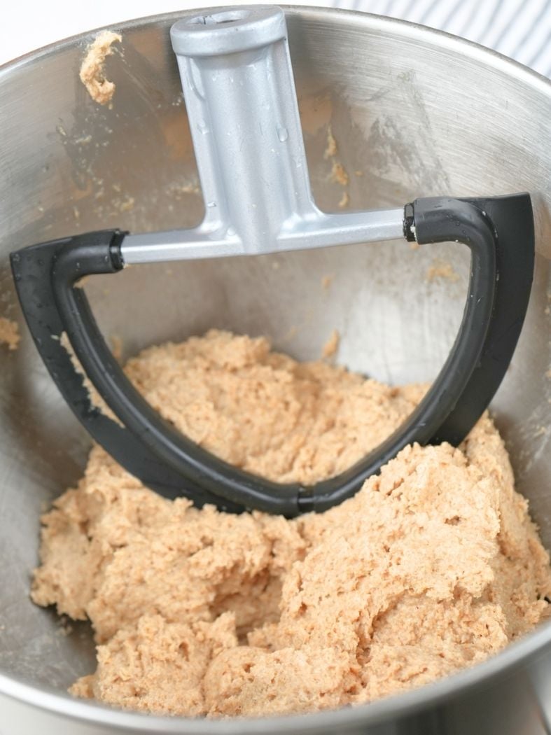 Combined dough in a stand mixer bowl, shown with the paddle attachment