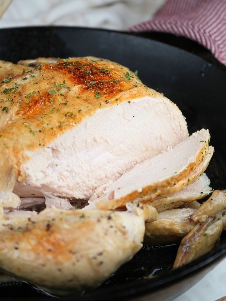 A whole chicken sliced to show the cooked breast