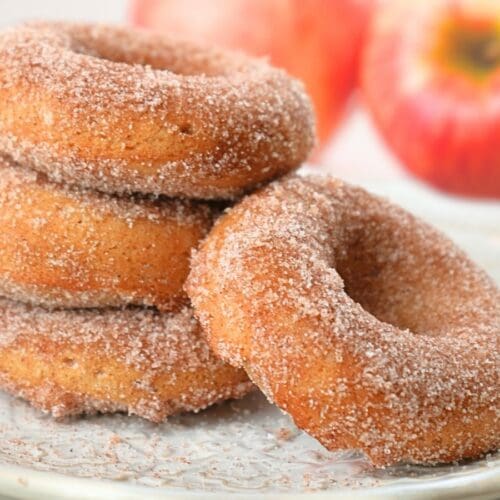 A stack of sourdough apple cider donuts on a plate.
