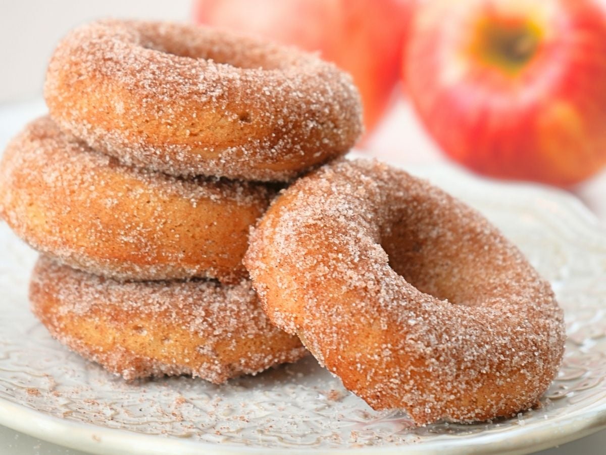 A stack of sourdough apple cider donuts on a plate.