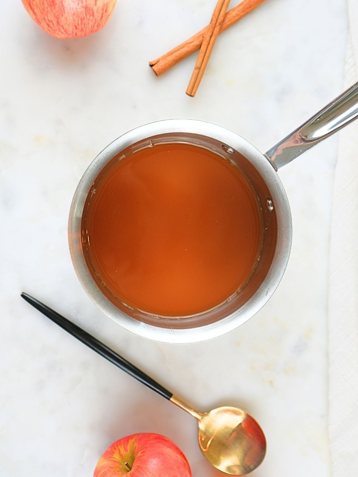 A saucepan filled with apple cider.