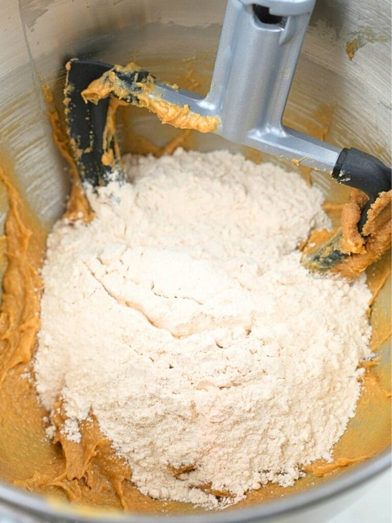 Flour on wet ingredients in a mixing bowl.