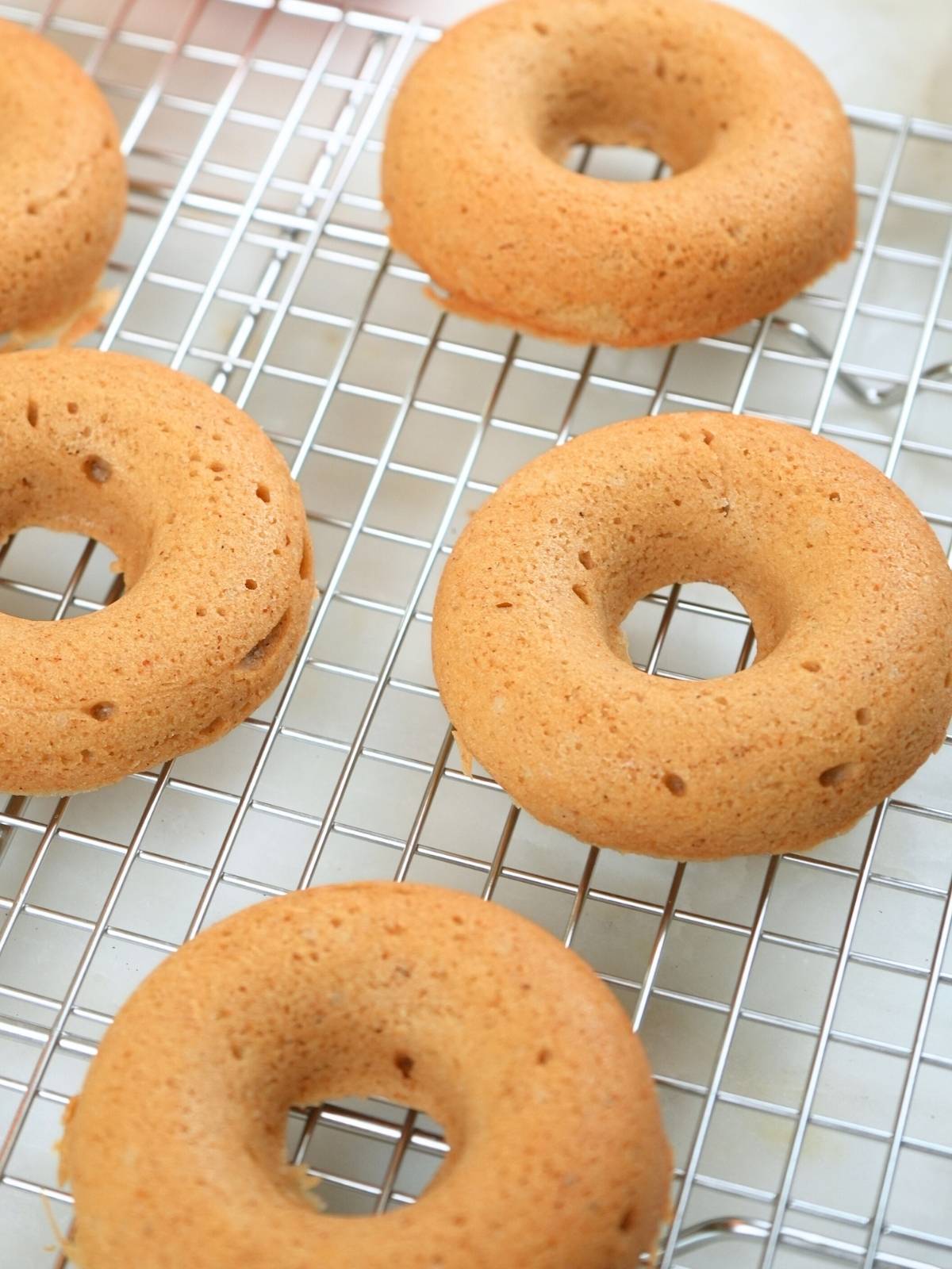 Baked donuts on a wire cooling rack.