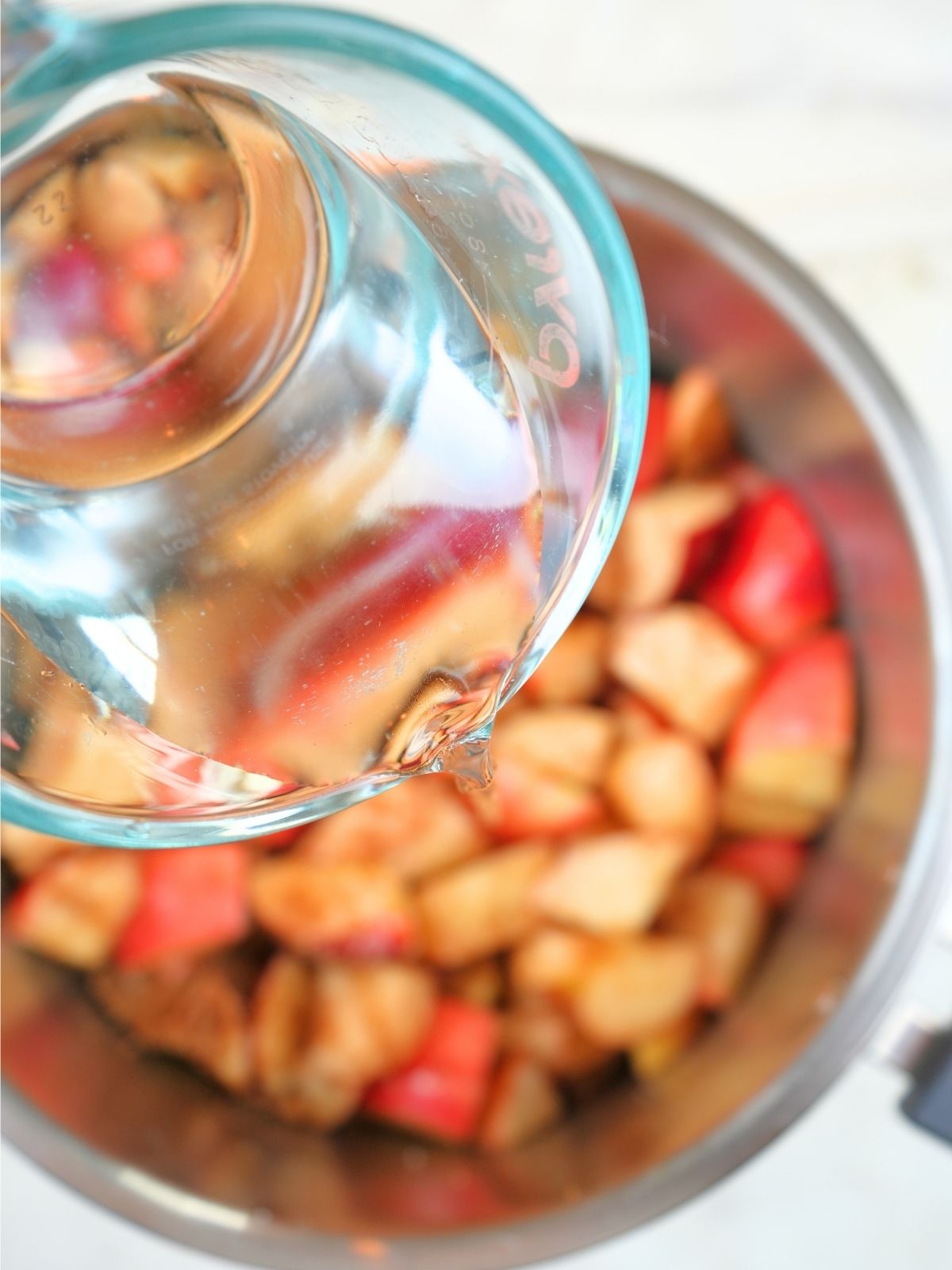 Water being poured over apples in an Instant Pot.