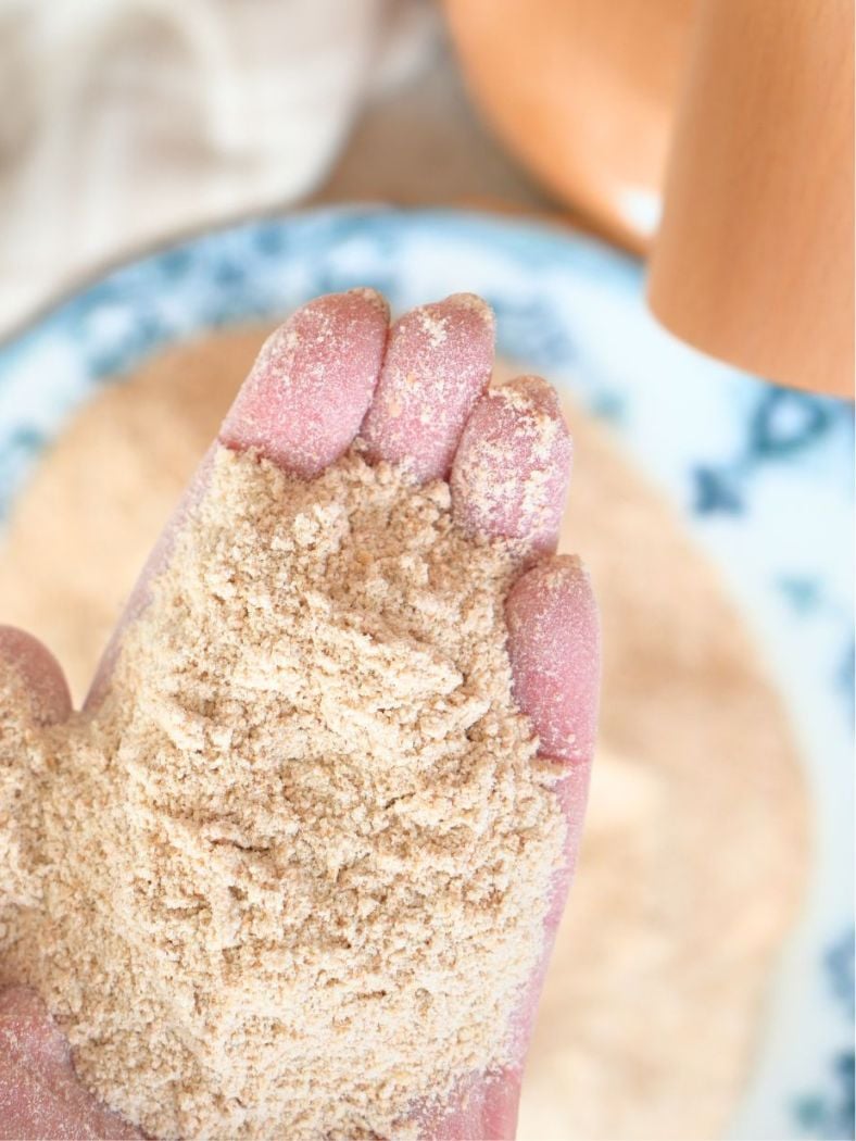 A hand holding freshly milled flour