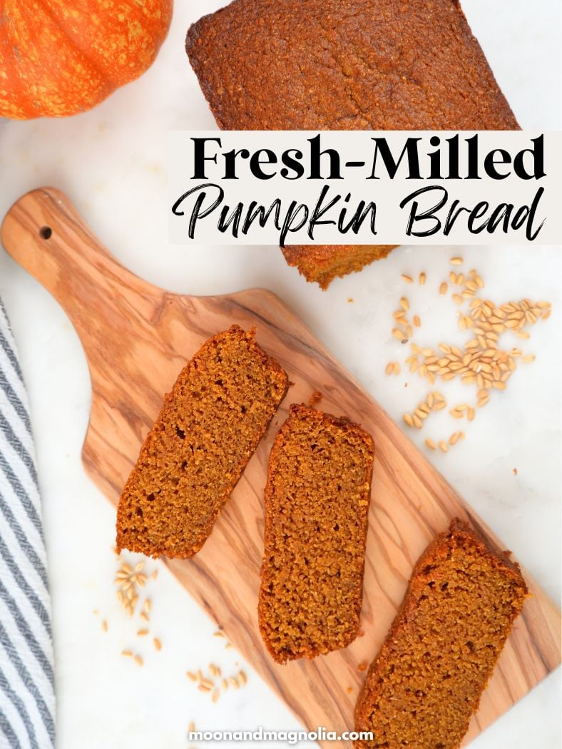 Slices of sweet bread on a wood tray, next to a whole loaf and a pumpkin. Text overlay says, "Fresh-Milled Pumpkin Bread"