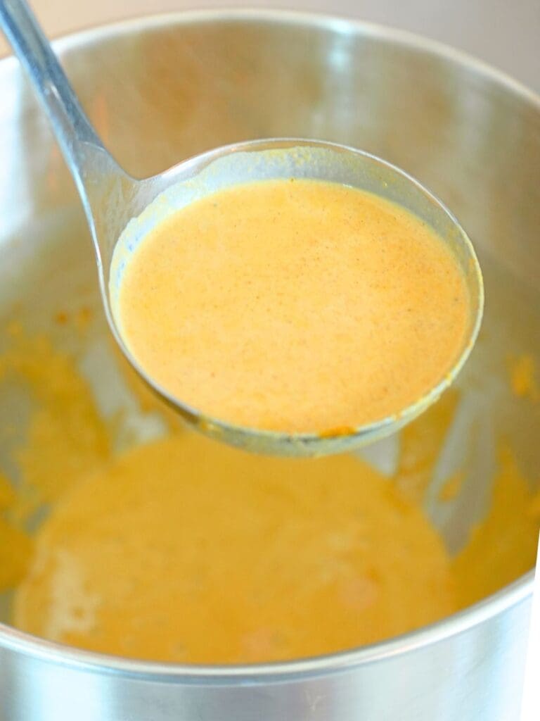 A ladle filled with egg mixture.