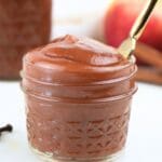 A small jar of Instant Pot apple butter with a butter knife.
