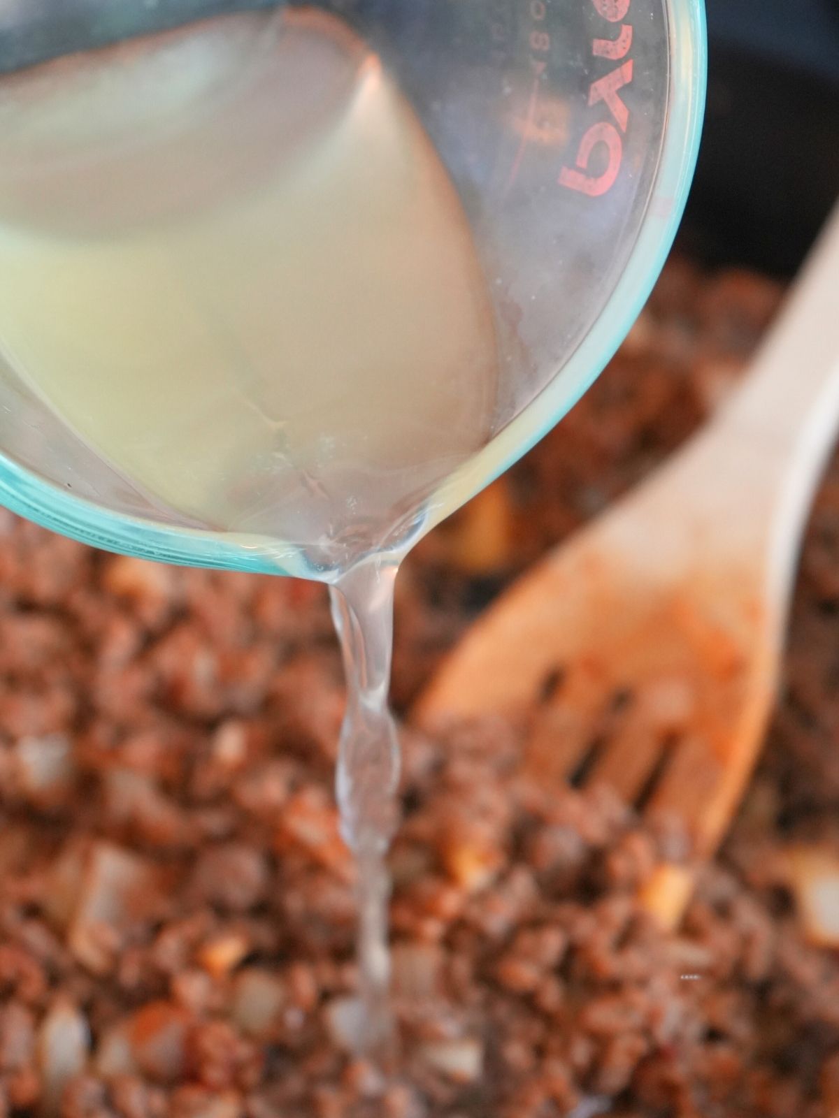 Chicken broth being poured into meat filling.