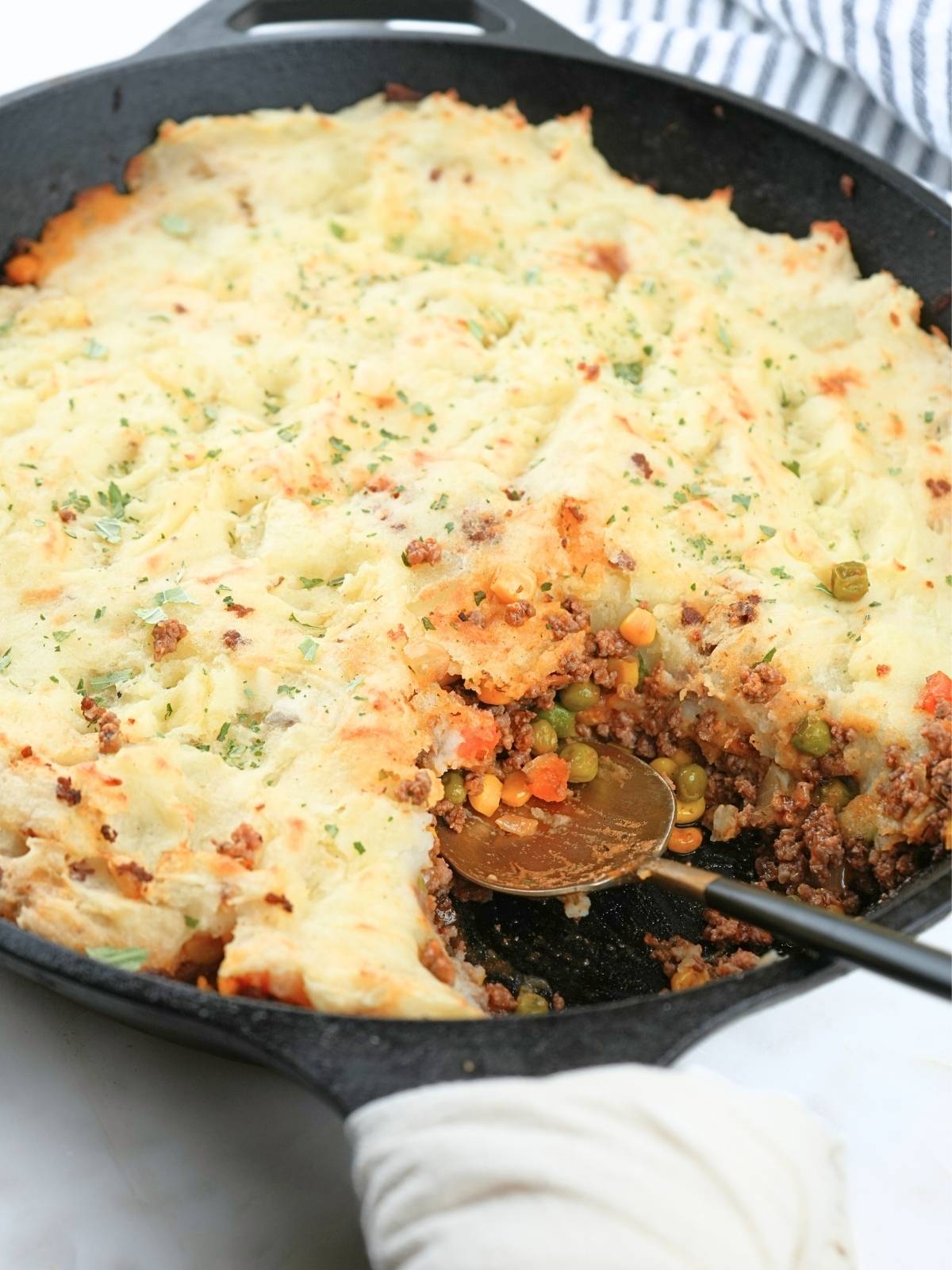 A shepherd's pie with corn in a cast iron skillet.