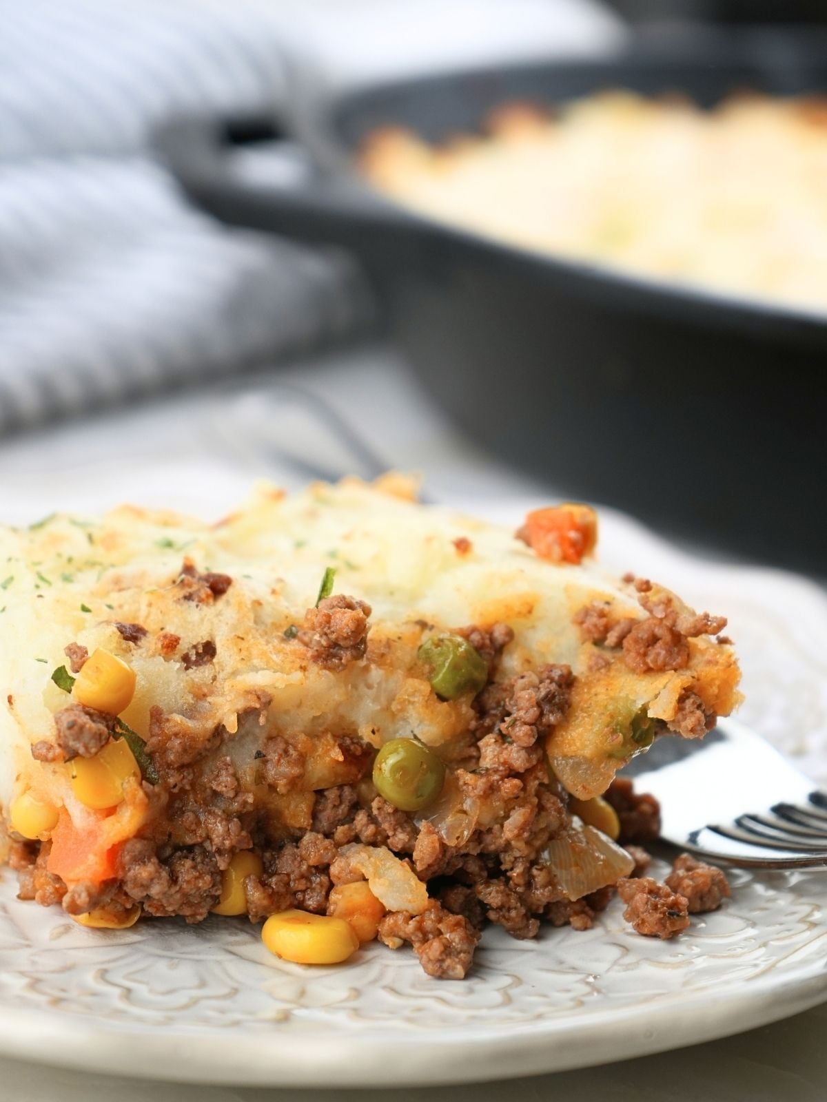 A scoop of shepherd's pie with corn on a plate.