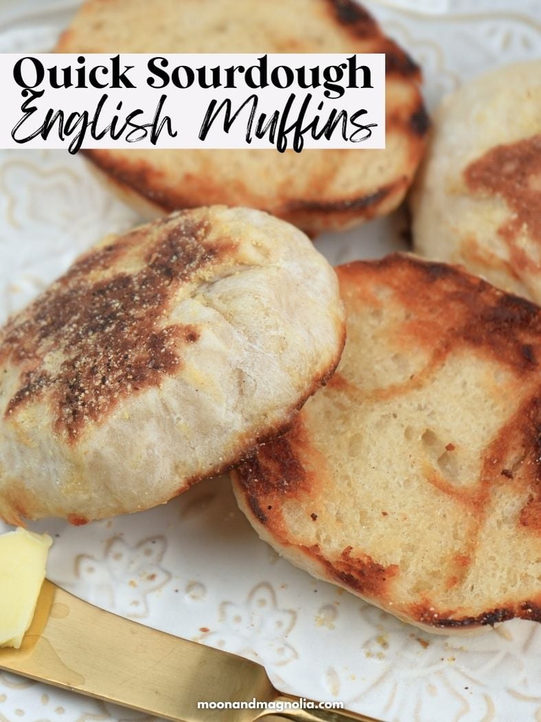 Close up of toasted English muffins and a knife with butter. Text overlay says, "Quick Sourdough English Muffins"