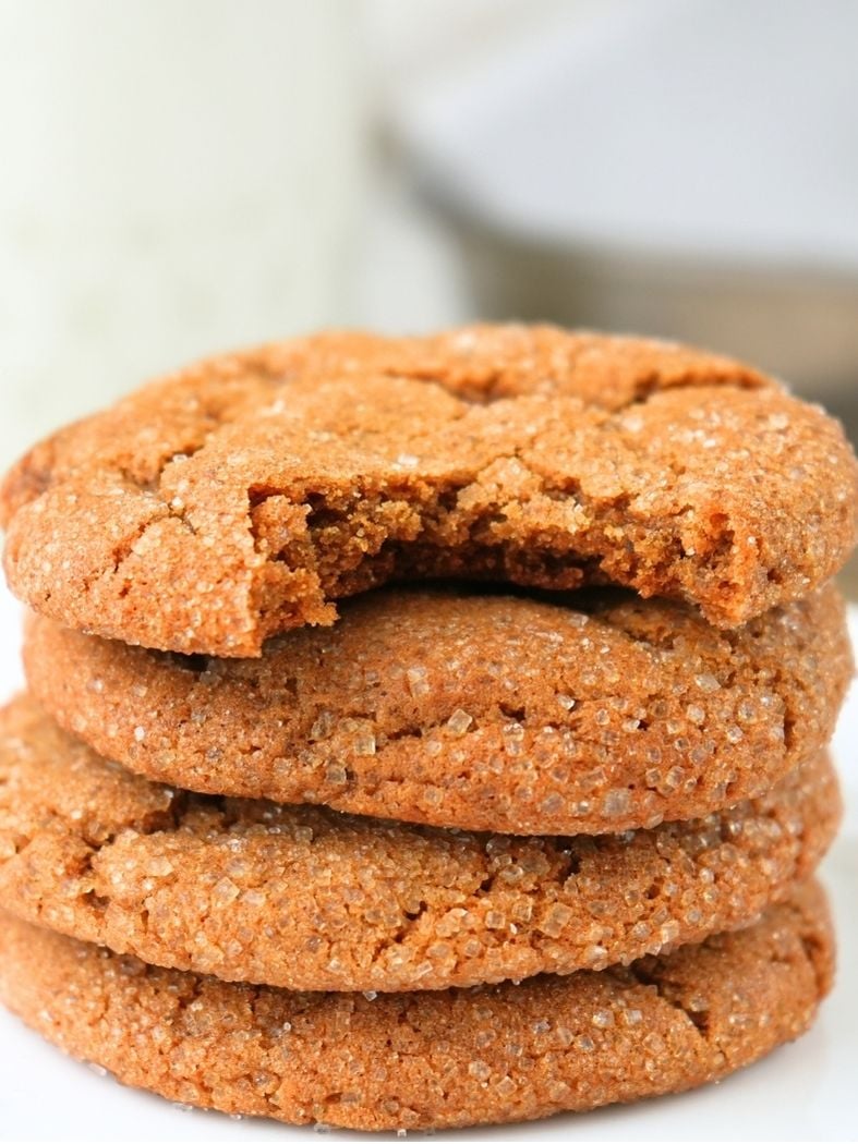 A stack of sourdough molasses cookies, a bite taken out of the top one.