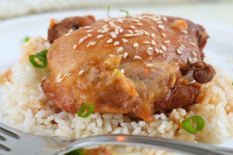Honey garlic chicken freezer meal, cooked and on a plate with rice and a fork
