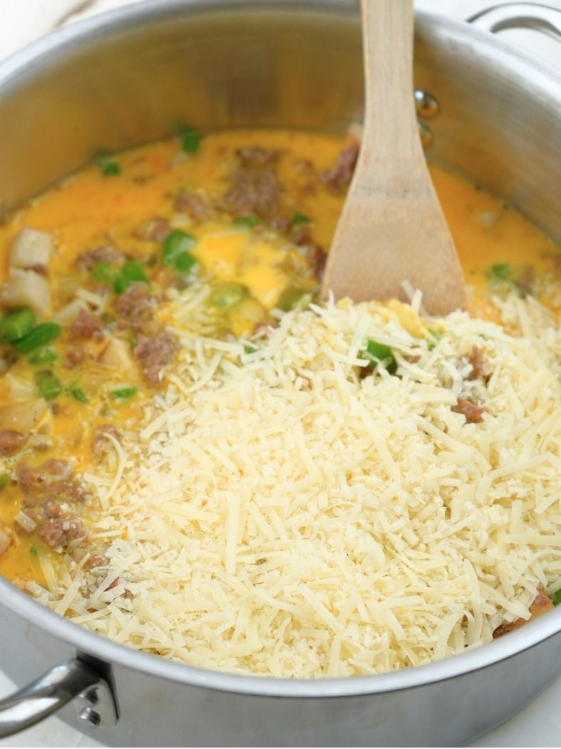 Sausage and egg mixture in a pot with parmesan cheese on top
