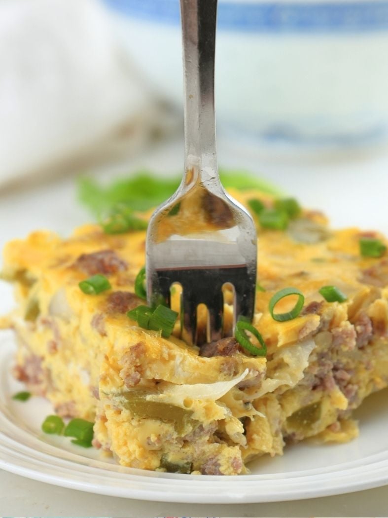 A fork piercing into a slice of slow cooker breakfast casserole