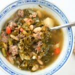 A bowl of one-pot sausage, kale, and white bean soup.