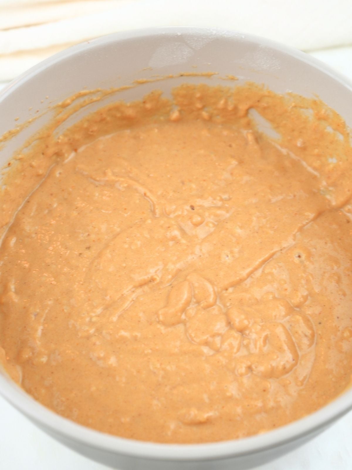 Pumpkin spice pancake batter in a mixing bowl.