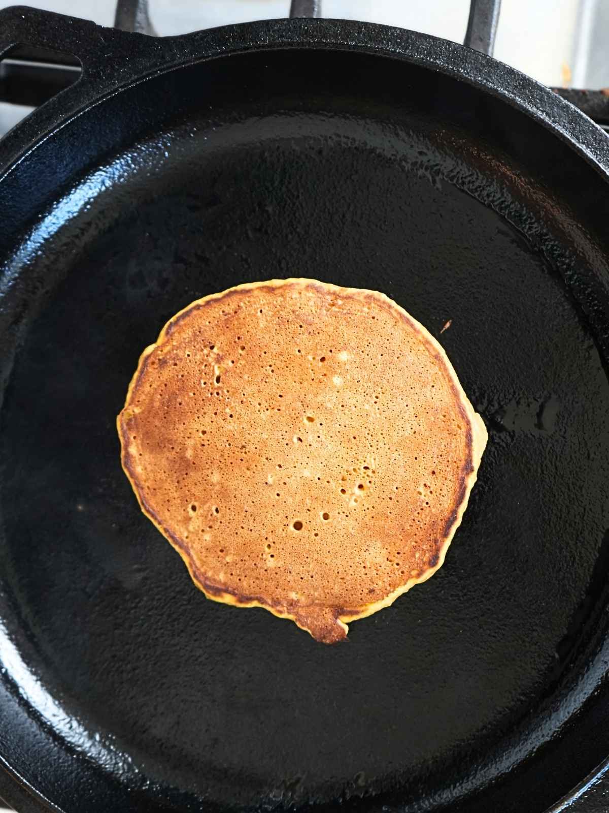 A pancake on a small cast iron skillet.
