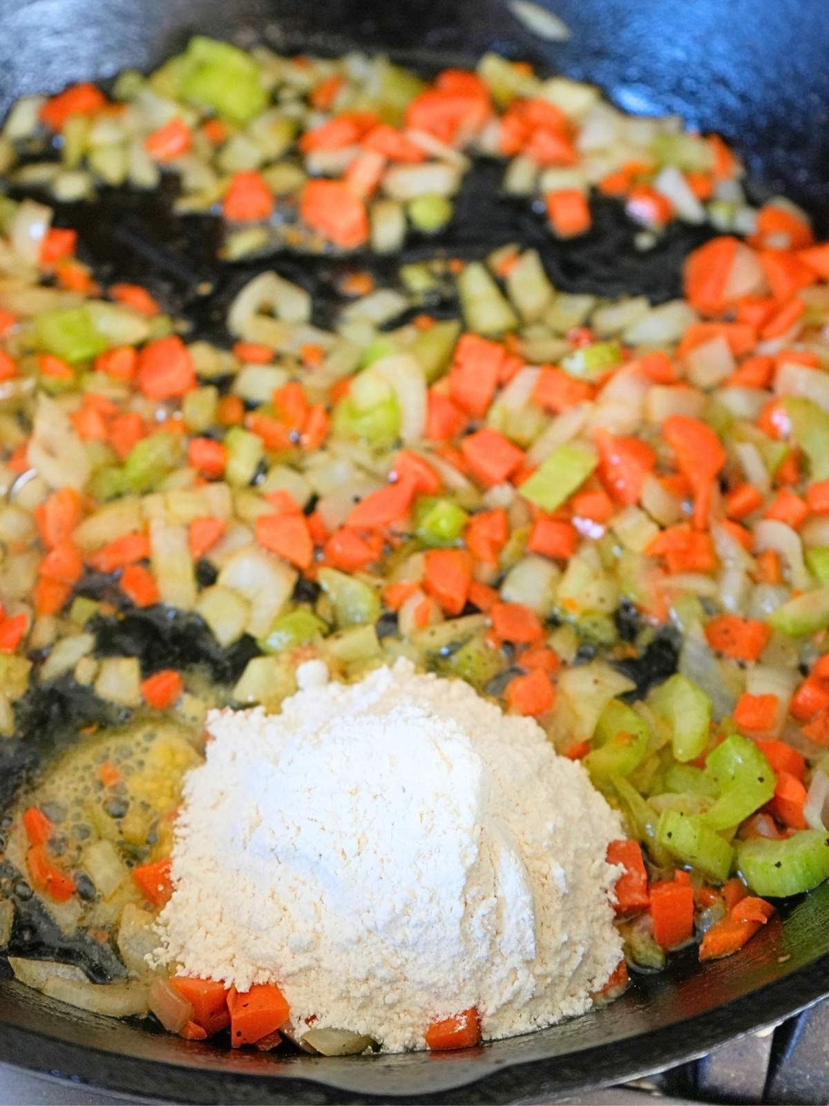Flour on top of sautéed vegetables.