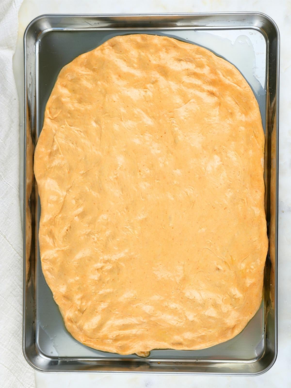 Dough shaped on an oiled baking sheet.