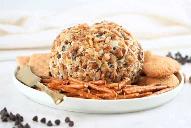 Chocolate chip cheese ball on a white platter with a variety of dippers