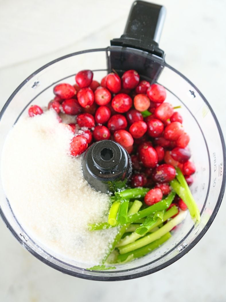 Cranberry salsa ingredients in a food processor bowl