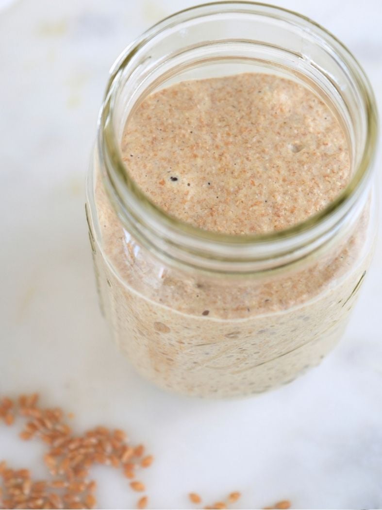 An overhead of einkorn sourdough starter in a small glass jar
