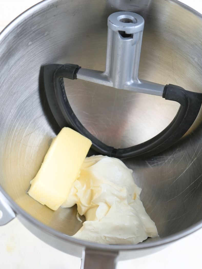 Cream cheese and butter in a stand mixer bowl with a paddle attachment