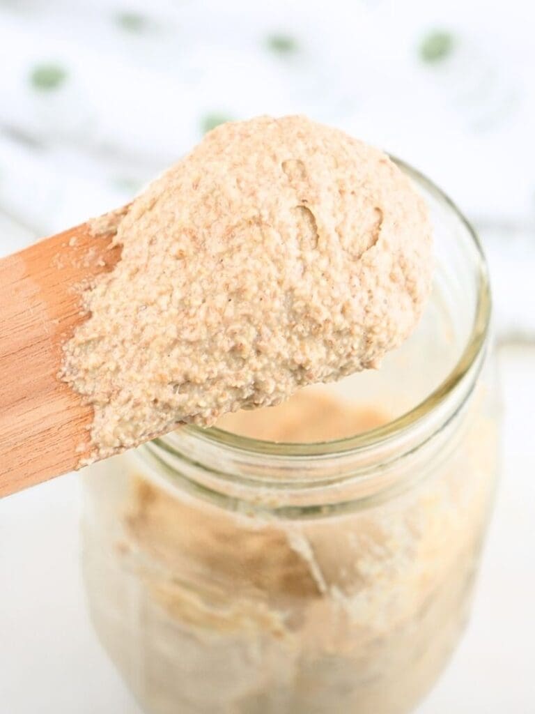 Thick sourdough starter on a wooden spurtle